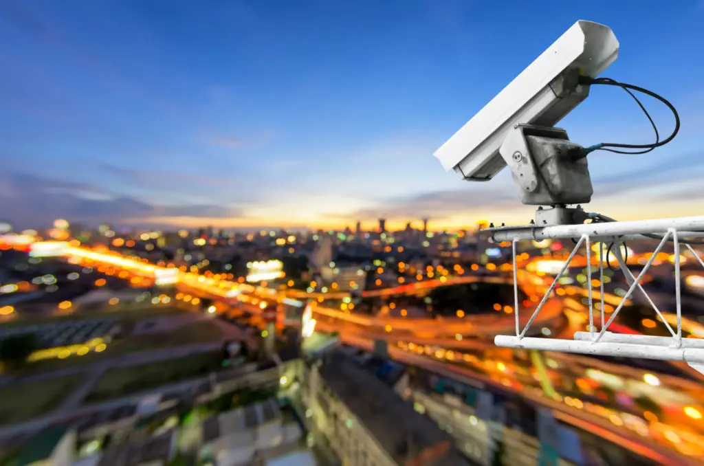 Камера видеонаблюдения над вечерним городом с 5G-связью