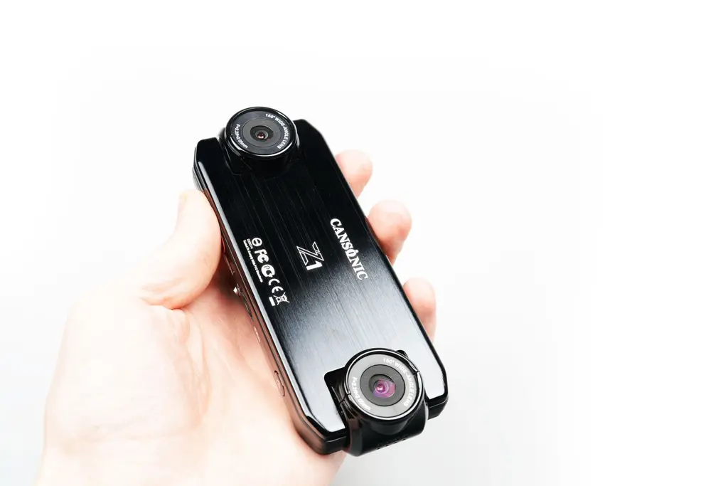 Видеорегистратор CANSONIC Z1 DUAL в руке рядом с выносной камерой