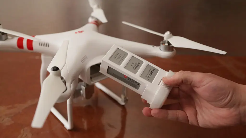 Рука держит аккумулятор рядом с DJI Phantom 2 Vision