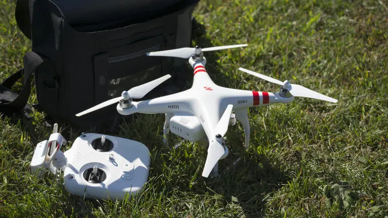 Квадрокоптер Phantom 2 Vision на траве рядом с пультом