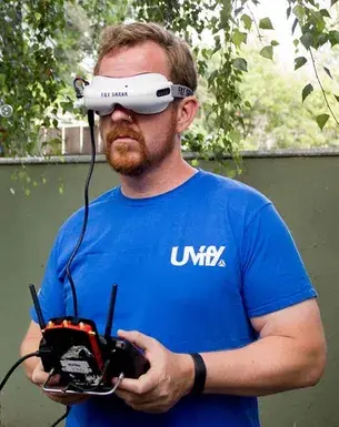 Пилот в FPV-очках с пультом управления в руках