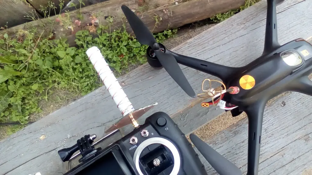 Дрон с FPV-антенной и пультом на траве