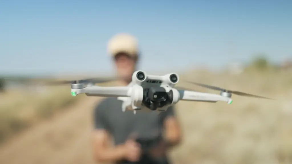 Мужчина запускает дрон DJI Mini 3 Pro на природе
