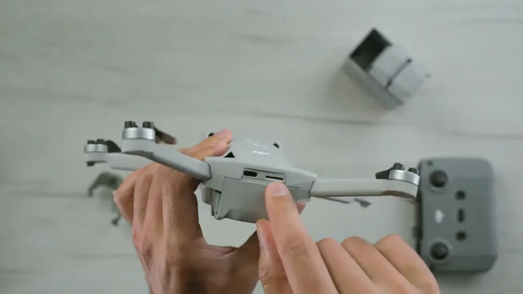 Руки складывают лучи квадрокоптера DJI Mini 3 Pro