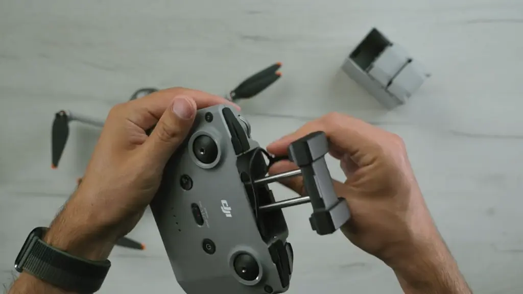 Руки держат пульт DJI RC-N1 с подключённым смартфоном