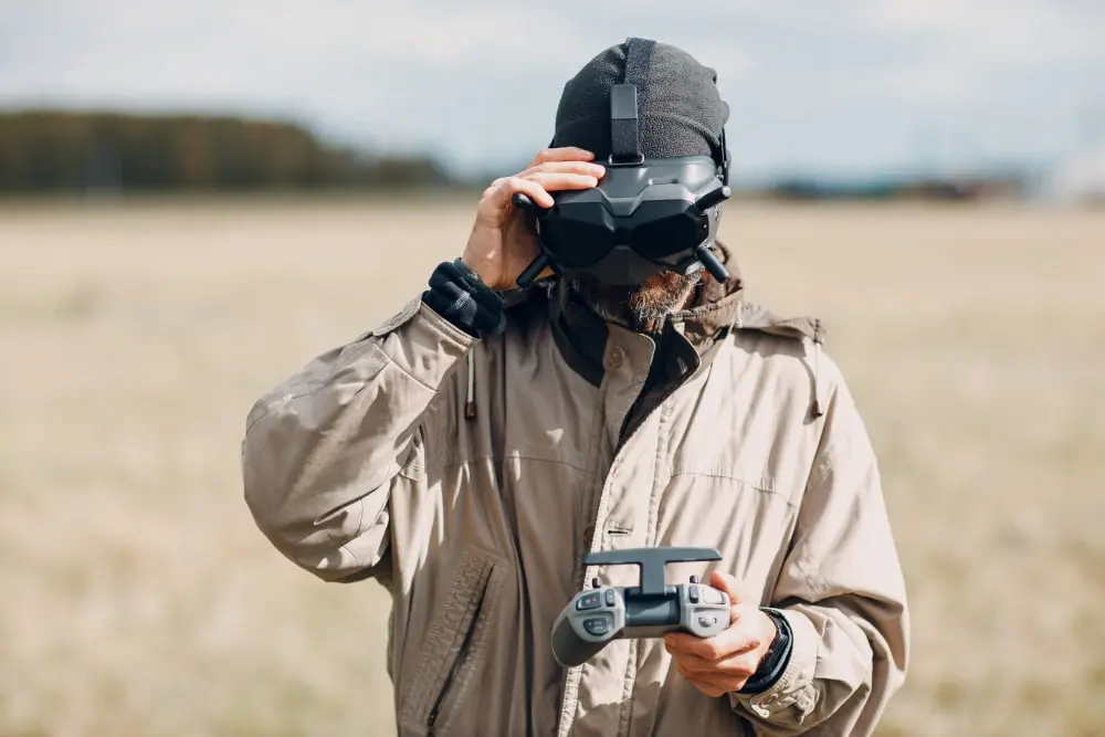 Пилот в FPV-очках с пультом на поле