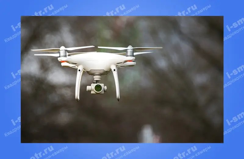 Белый квадрокоптер DJI Phantom 4 Pro в полёте